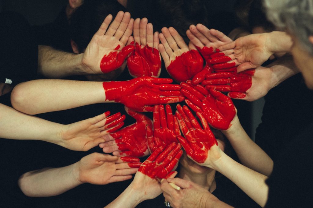 Hands with red heart painted on them